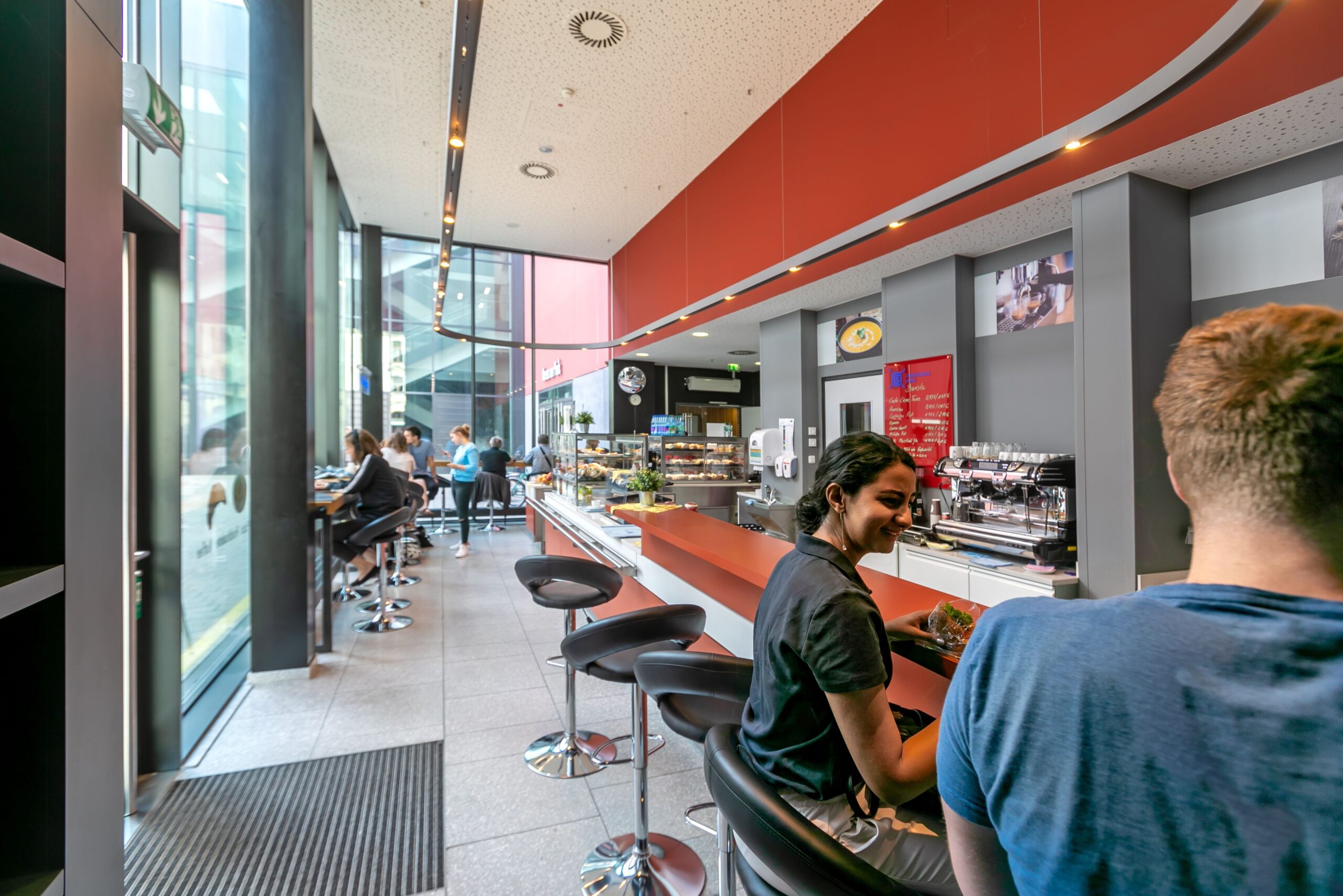 Students sit at a counter in the Bistro Mensa am Park.