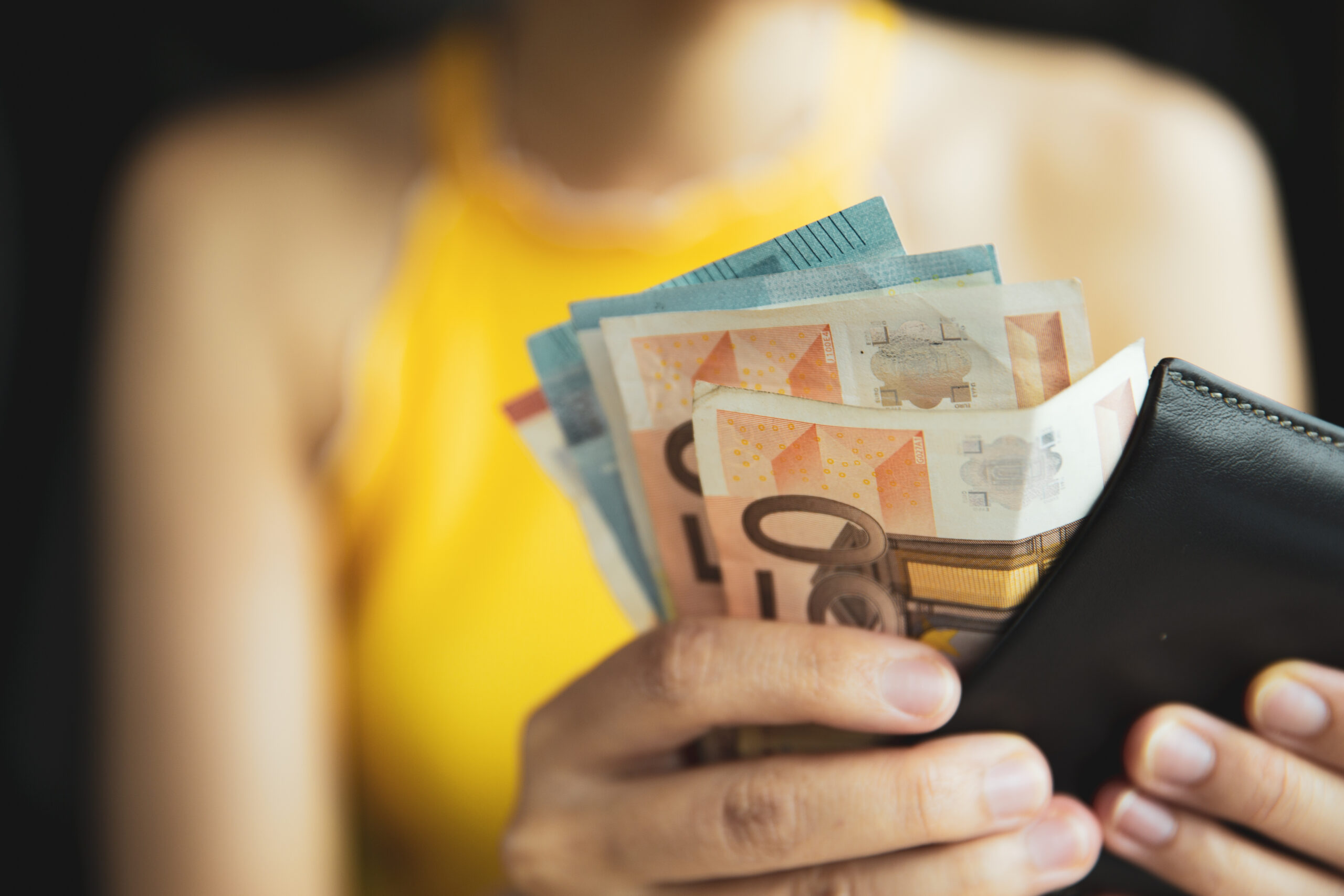 A female hand piking up or counting money in the wallet. Budget for travelling or purchacing.