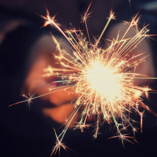 hands holding a burning sparkler